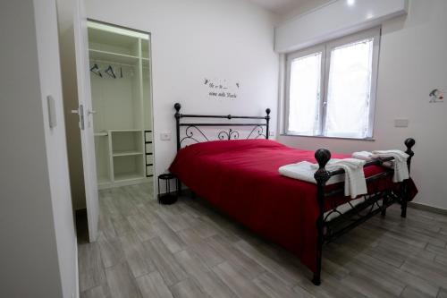 1 dormitorio con cama roja y ventana en RESIDENZA IL ROCCOLO en San Fermo della Battaglia