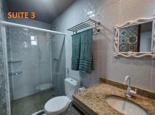 La salle de bains est pourvue de toilettes, d'un lavabo et d'une douche. dans l'établissement Apartamento com três suítes em Garanhuns próximo ao Parque Euclides Dourado, à Garanhuns