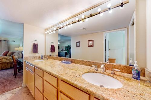 uma casa de banho com um lavatório e um espelho grande em Pink Bloom Sanctuary em Scottsdale
