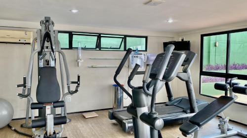 a gym with two treadmills and two ellipticals at Natal Plaza in Natal