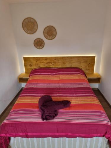łóżko z kolorowym kocem na górze w obiekcie CA PRICHU w mieście Calabaza