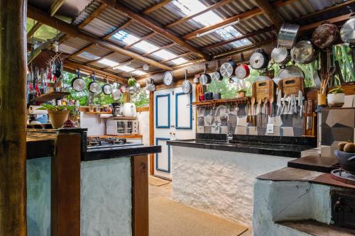 una cocina con ollas y sartenes colgadas en la pared en Ondas da Grande Spa Cama e Café, Praia Grande, Penha, Santa Catarina, en Penha