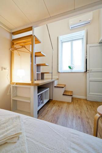 a room with a bed and a desk and a window at La porta di mezzo in Catania