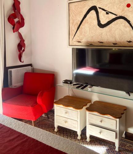 a living room with a red chair and a fireplace at Espaço Viverde Penedo in Penedo