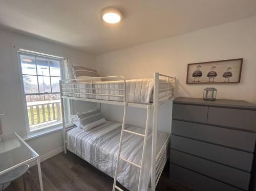 - une petite chambre avec des lits superposés et une fenêtre dans l'établissement Cricker's Corner Vacation Home, North Rustico, PEI, à North Rustico