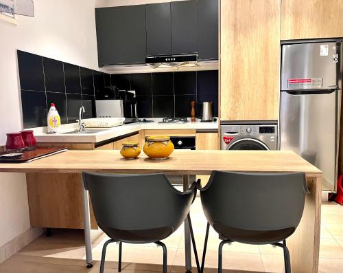a kitchen with a wooden table and two chairs at Forest View Apartments in Kololi