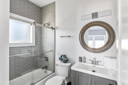a bathroom with a toilet and a sink and a mirror at Fire Island White House - Ocean Bay Park, NY in Ocean Beach