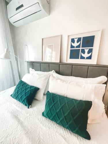 um quarto com uma cama com almofadas verdes e brancas em Studio Novissimo Perto do Copacabana Palace no Rio de Janeiro
