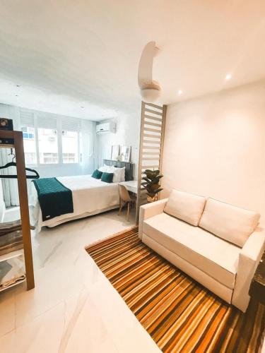 uma sala de estar com um sofá e uma cama em Studio Novissimo Perto do Copacabana Palace no Rio de Janeiro