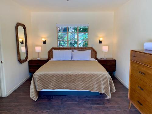 a bedroom with a bed and a window and a dresser at Vista Grande Resort - A Gay Men's Resort in Palm Springs