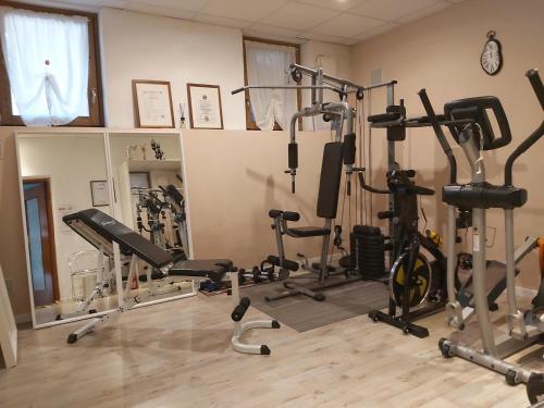 a gym with several treadmills and exercise bikes at B&B VALCHISONE in Pinasca 