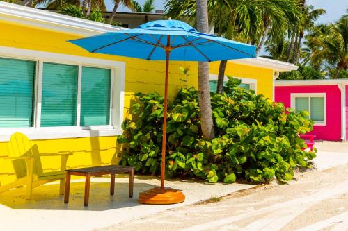 a blue umbrella and a bench next to a house at La Siesta Resort & Villas in Islamorada