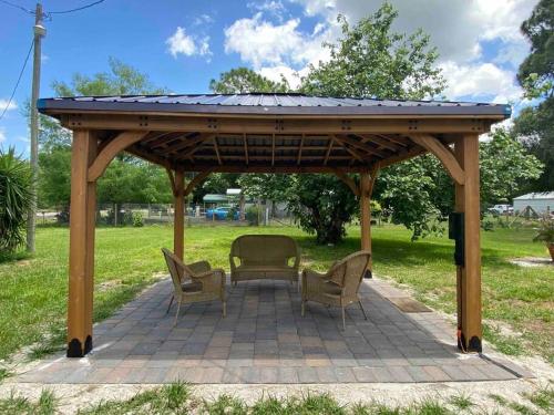 a wooden gazebo with chairs and a table at Rancho Alegre. Bring your boat and RV too! in Clewiston