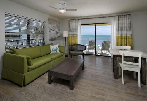 a living room with a green couch and a table at La Siesta Resort & Villas in Islamorada