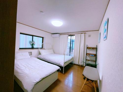 a small bedroom with two beds and a window at 美山小屋-临近东京夏日乐园，高尾山，相模湖游乐园 in Hachioji