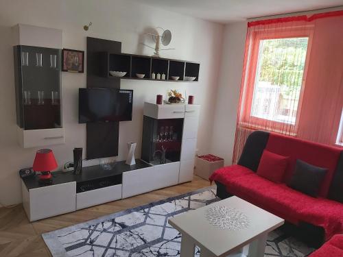 a living room with a red couch and a flat screen tv at Stan na dan-Vasilije in Zvornik