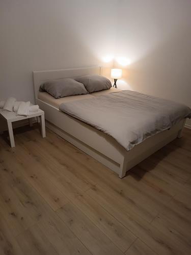 a bedroom with a bed with a lamp and a wooden floor at Ksenia in Neumünster