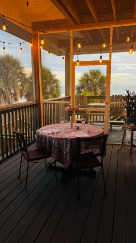 a table on a screened porch with a table and chairs at Turtle Beach Inn in Indian Pass