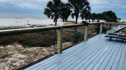 a wooden deck with a bench on the beach at Turtle Beach Inn in Indian Pass