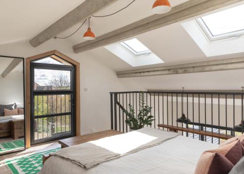 a bedroom with a bed and a balcony with windows at The Studio at The Grain Store in Falmer