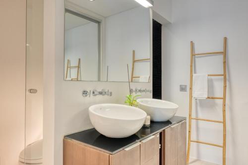 a bathroom with two sinks and a mirror at Jasmineiro, a Home in Madeira in Funchal