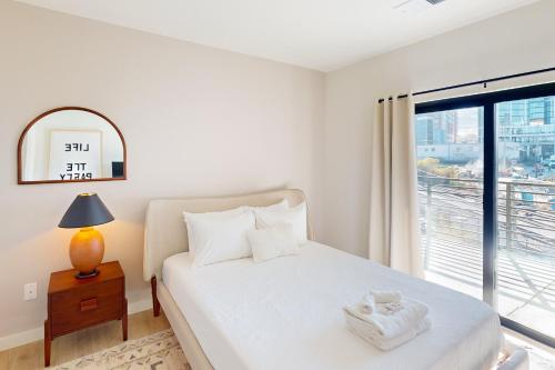 a bedroom with a white bed with a window at Life of the Party, Unit #418 in Nashville
