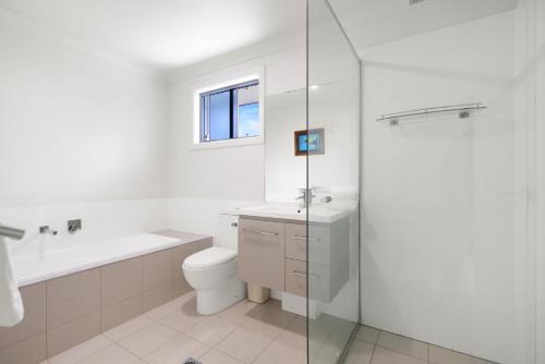 ein Bad mit einem WC, einem Waschbecken und einer Dusche in der Unterkunft Riptide in Coffs Harbour
