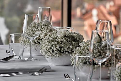 a table with wine glasses and flowers on it at Holiday Inn Gdansk - City Centre by IHG in Gdańsk