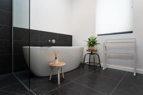 a bathroom with a bath tub and a table at The Studio at The Grain Store in Falmer