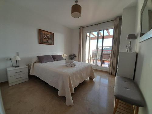 a bedroom with a bed and a large window at Feel The Vibe Alcaidesa in San Roque