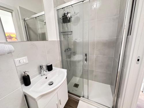 bagno bianco con doccia e lavandino di Calima apartments a Marghera