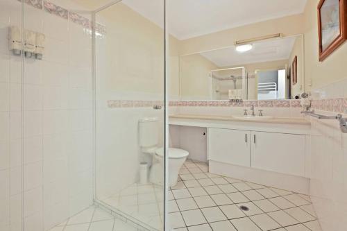 a bathroom with a toilet and a glass shower at Tangalooma Beachfront Villa 23 2 bedroom in Tangalooma
