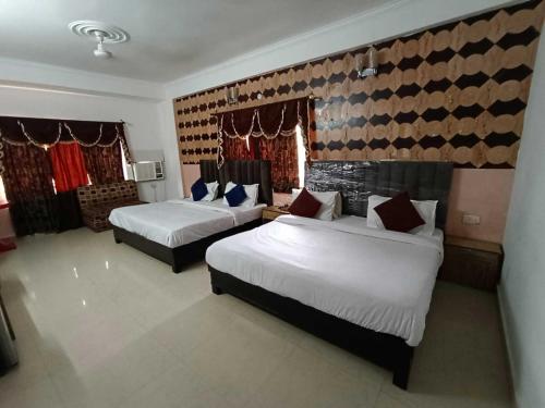 a hotel room with two beds in a room at Collection O Hotel Gordon House in Katra