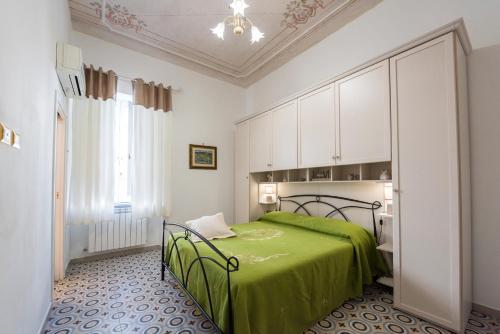 a bedroom with a green bed and white cabinets at Le Bijou Luxury Apartment in Salerno