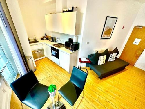een woonkamer met een bank en stoelen en een keuken bij V05 Fantastic Apartment - Piccadilly Circus on Doorstep! in Londen