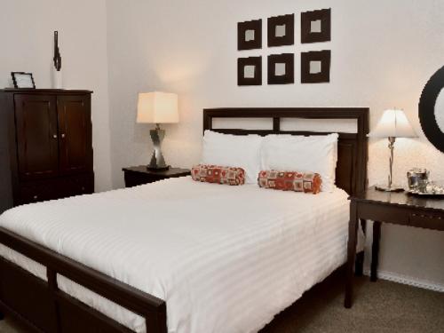 een slaapkamer met een groot wit bed met 2 kussens bij El Primero Boutique Hotel in Chula Vista