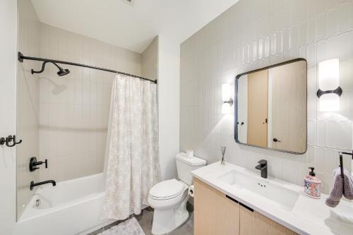 a bathroom with a sink and a toilet and a mirror at Luxe Schweitzer Condo with Hot Tub Ski-InandSki-Out! in Sandpoint