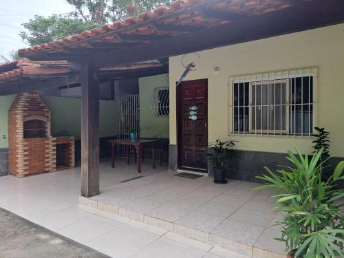 dom z drewnianymi drzwiami i patio w obiekcie Casa de temporada Lar Doce Mar de Itauna w mieście Saquarema