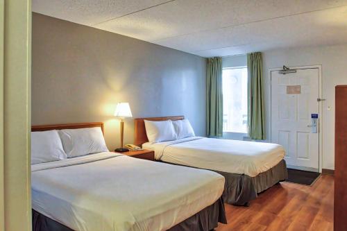 a hotel room with two beds and a window at Motel 6-Buffalo, NY - Airport - Williamsville in Williamsville