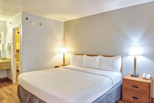 a large bed in a hotel room with two lamps at Motel 6-Buffalo, NY - Airport - Williamsville in Williamsville