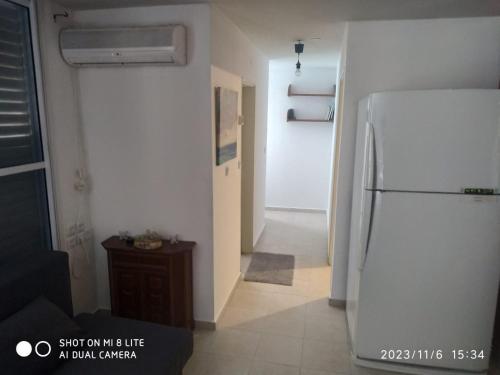 een keuken met een witte koelkast en een hal bij amir private apartment's in Tel Aviv
