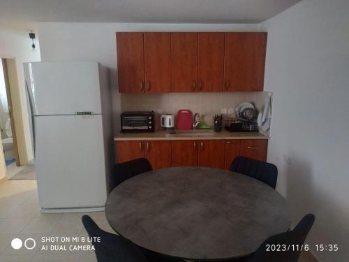 een keuken met een tafel en een witte koelkast bij amir private apartment's in Tel Aviv