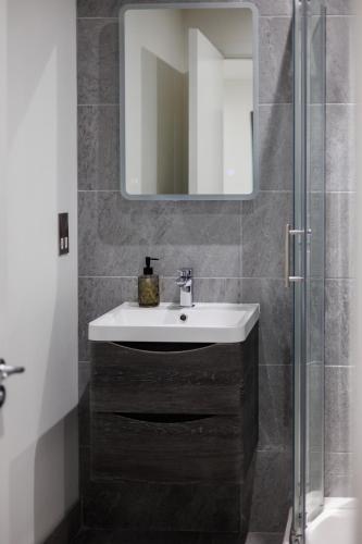 a bathroom with a sink and a mirror at Charming 2BR apt in the Heart of Belfast City in Belfast