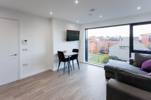 a living room with a couch and a table at Charming 2BR apt in the Heart of Belfast City in Belfast
