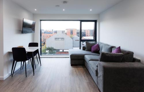 a living room with a couch and a table at Charming 2BR apt in the Heart of Belfast City in Belfast
