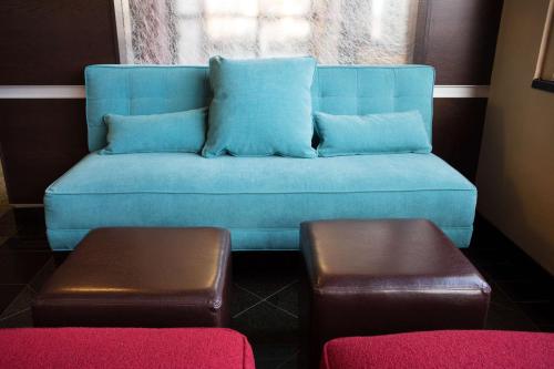a blue couch sitting in a room with a window at Drury Inn & Suites Springfield MO in Springfield