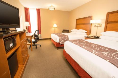 a hotel room with two beds and a flat screen tv at Drury Inn & Suites Springfield MO in Springfield