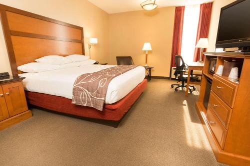 a hotel room with a bed and a flat screen tv at Drury Inn & Suites Springfield MO in Springfield