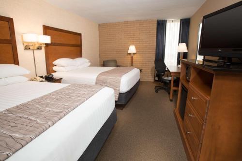 a hotel room with two beds and a flat screen tv at Drury Inn & Suites Champaign in Champaign
