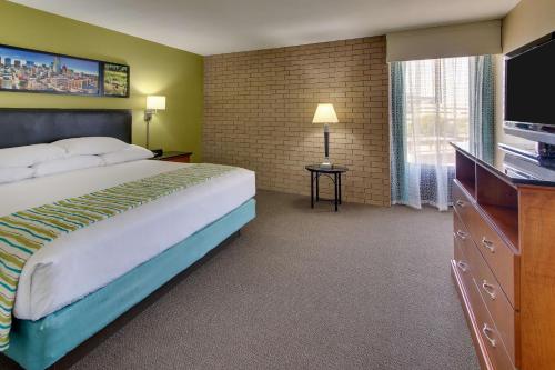 um quarto de hotel com uma cama e uma televisão de ecrã plano em Drury Inn & Suites Houston Sugar Land em Sugar Land